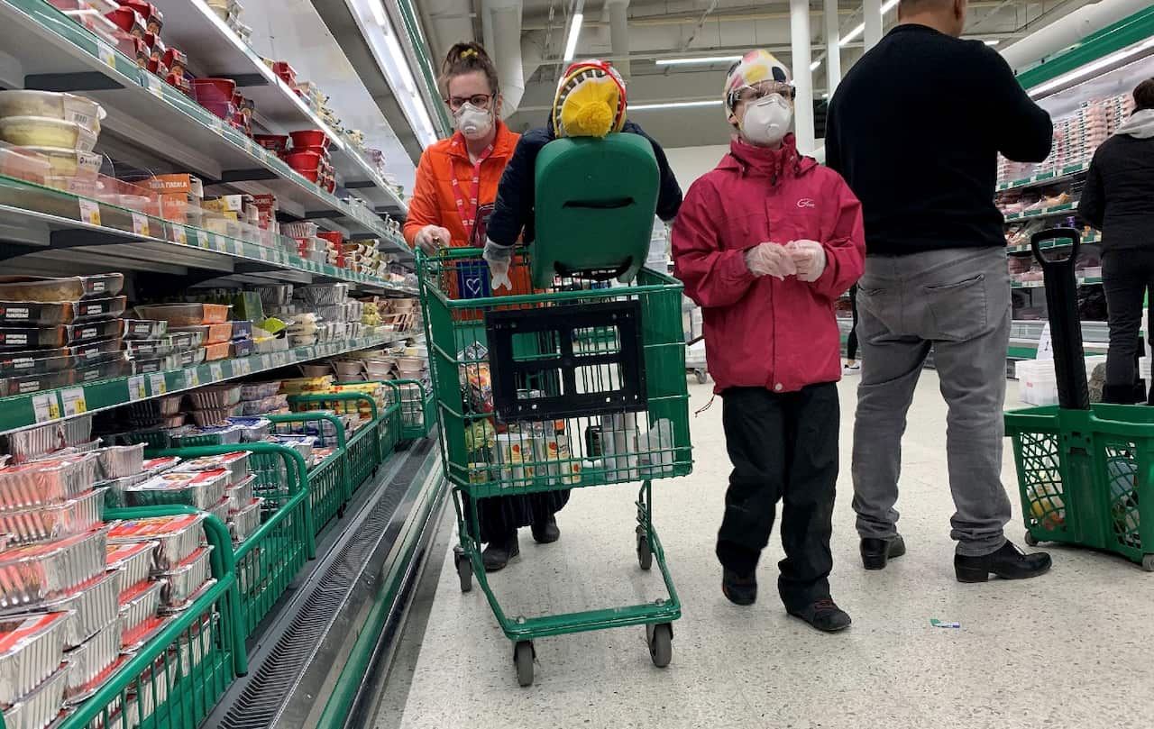 A woman and a child wear face masks as they do their shopping in a supermarket in Vaasa, Finland on 28 March 2020.
