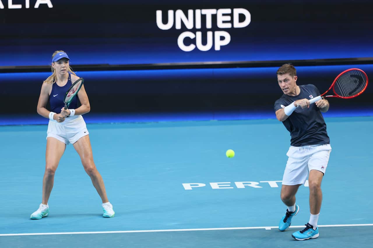 A mixed tennis doubles team, with a female and male player out on a tennis court.