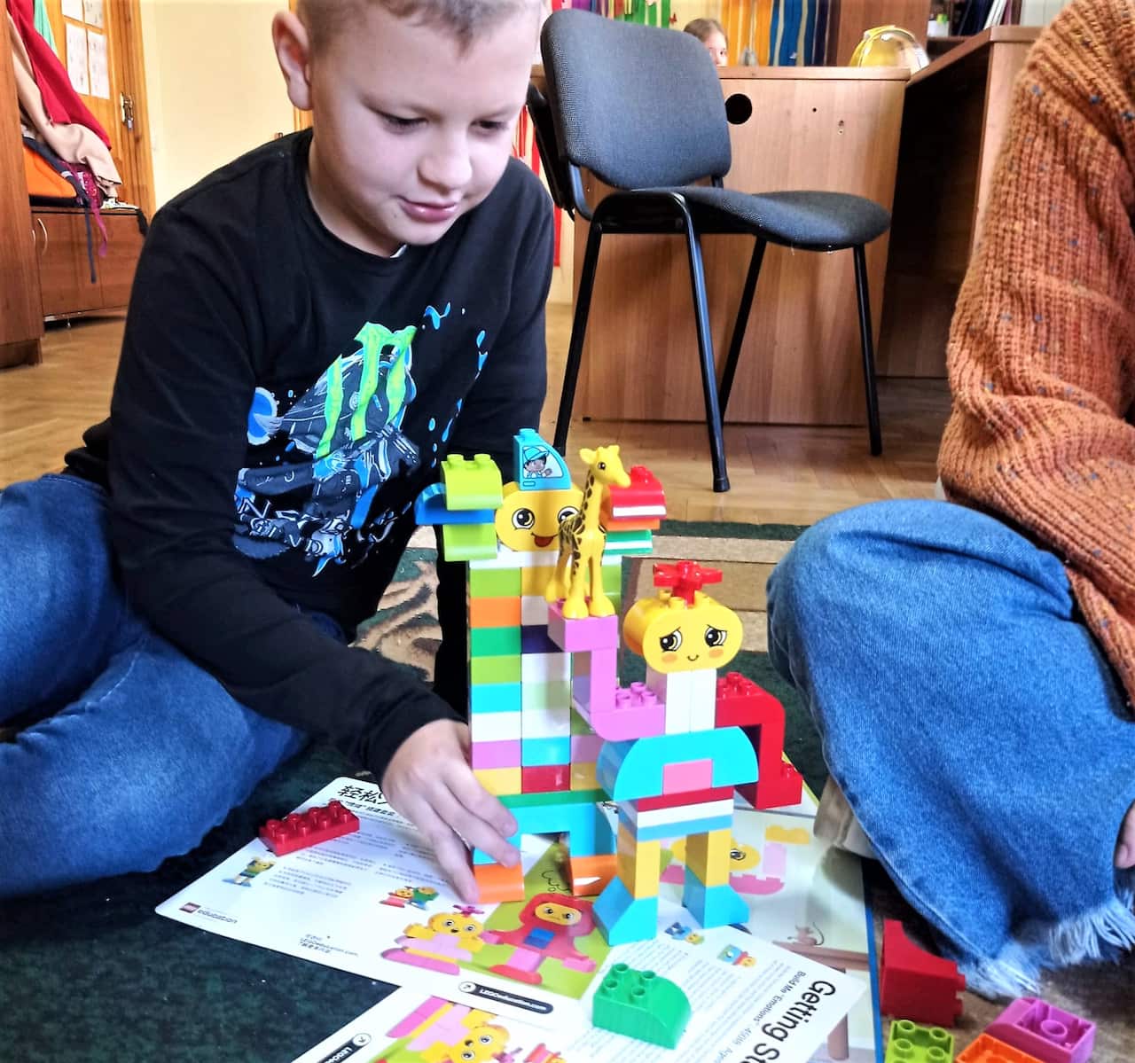 A young boy playing with toys in an emergency housing shelter.