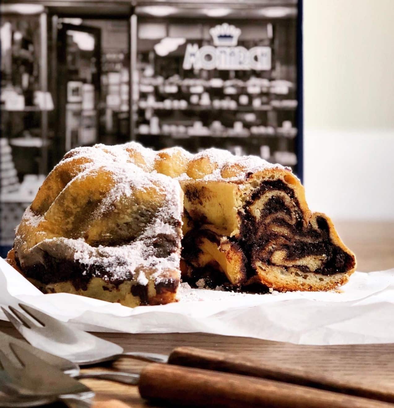 A chocolate swirl cake sliced open on a platter.