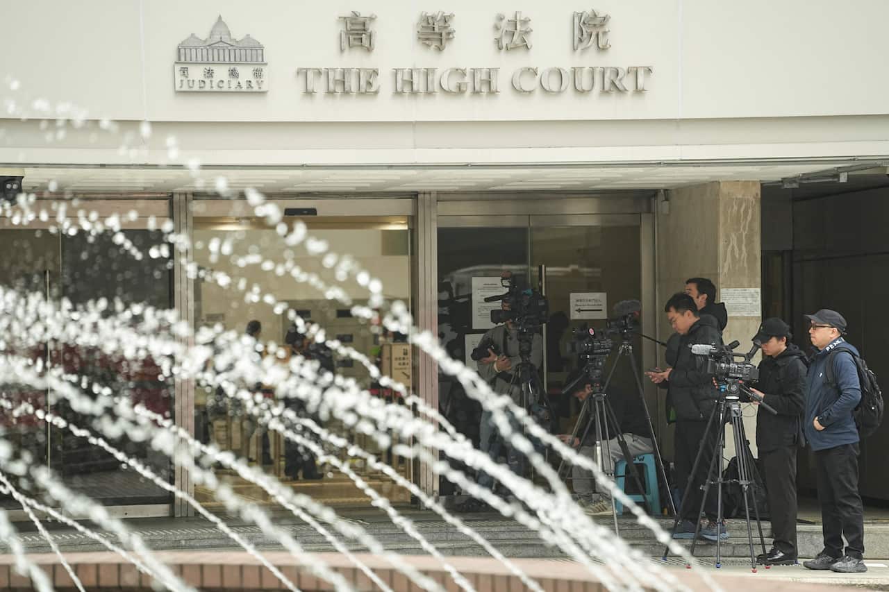 Media members stand outside the High Court where a court hearing on property developer China Evergrande Group is held, in Hong Kong