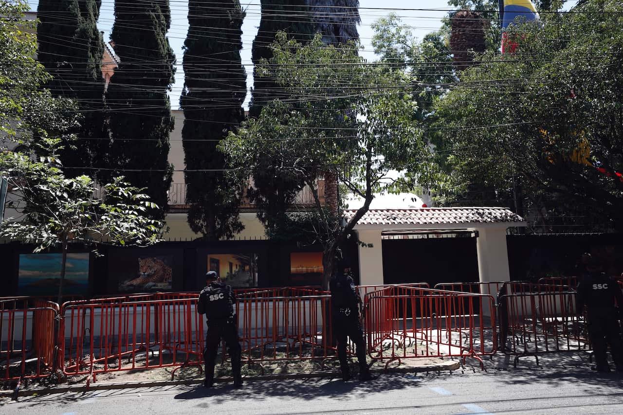 Guards stand outside a fenced off building