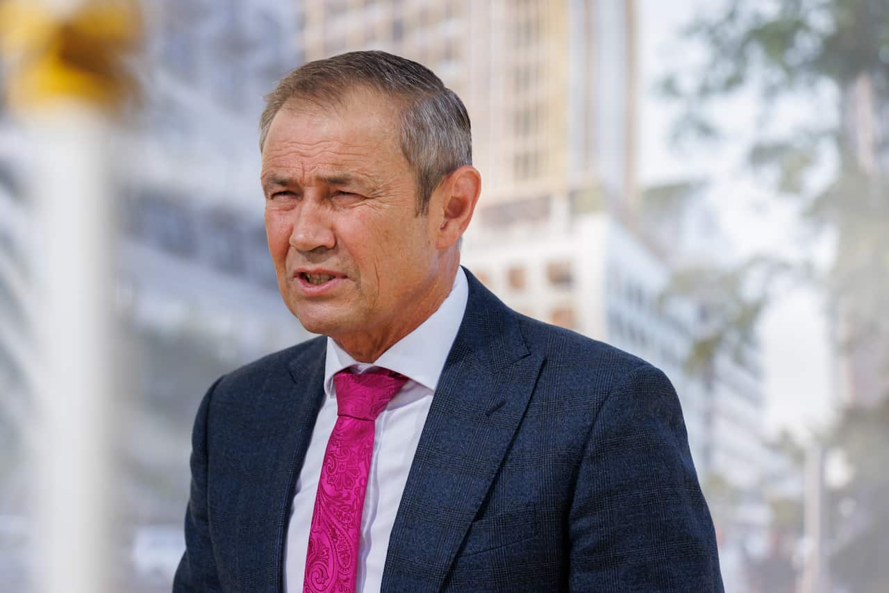 Roger cook speaking while wearing a suit.