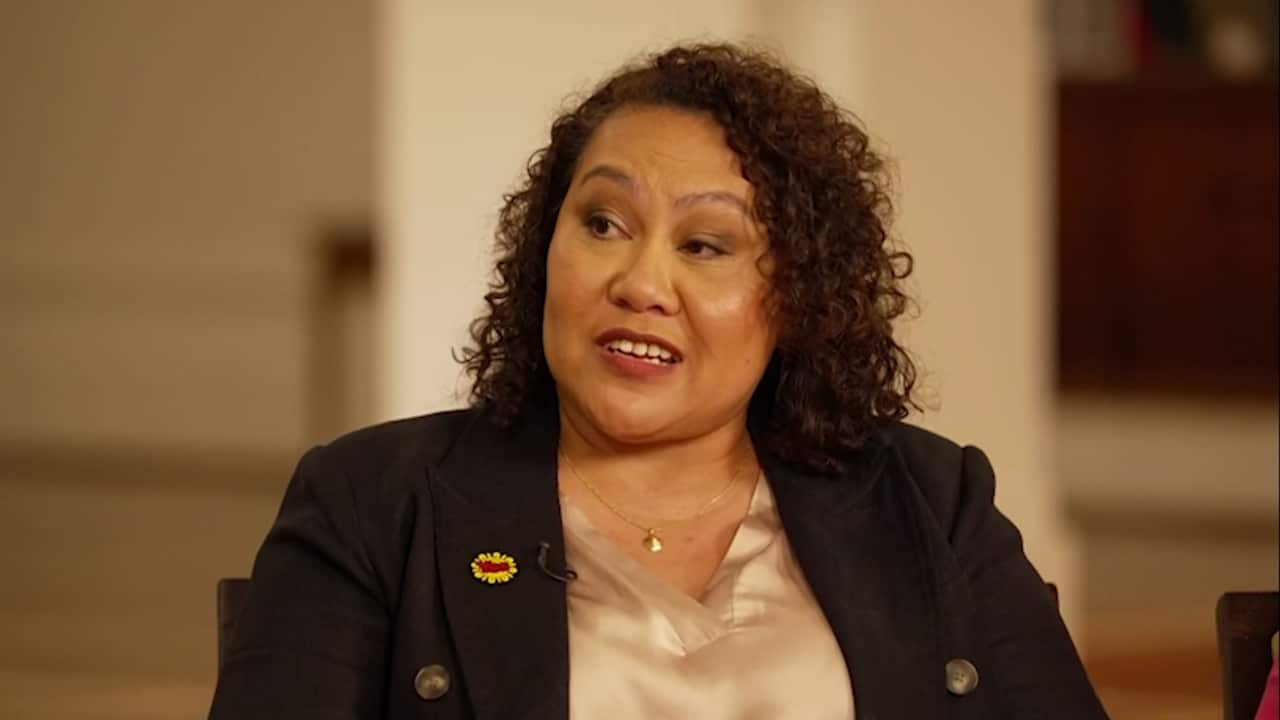 A woman wearing a blazer with a "Yes" badge.