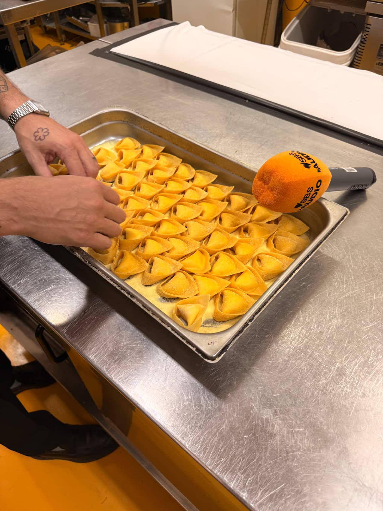 Una teglia di tortelloni cacio e pepe pronta per essere cotta.