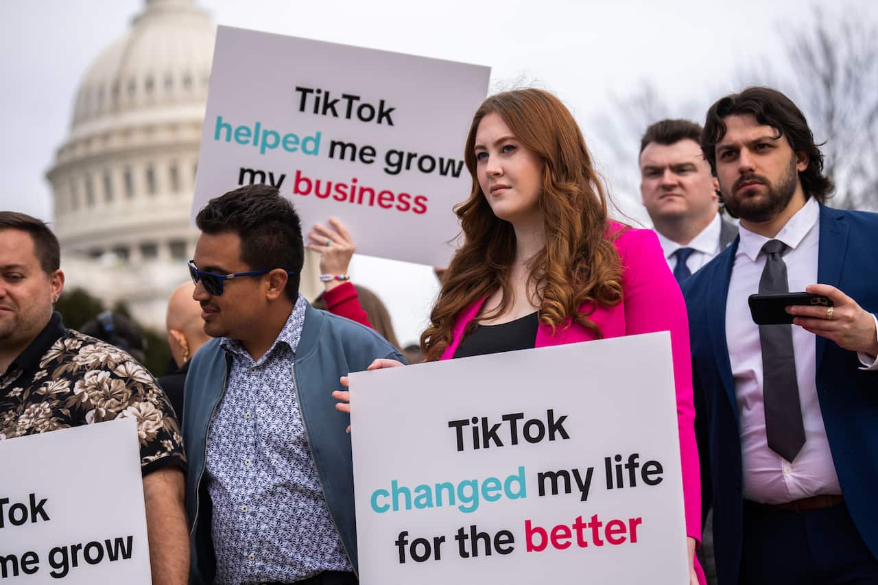 People stand in a group holding signs
