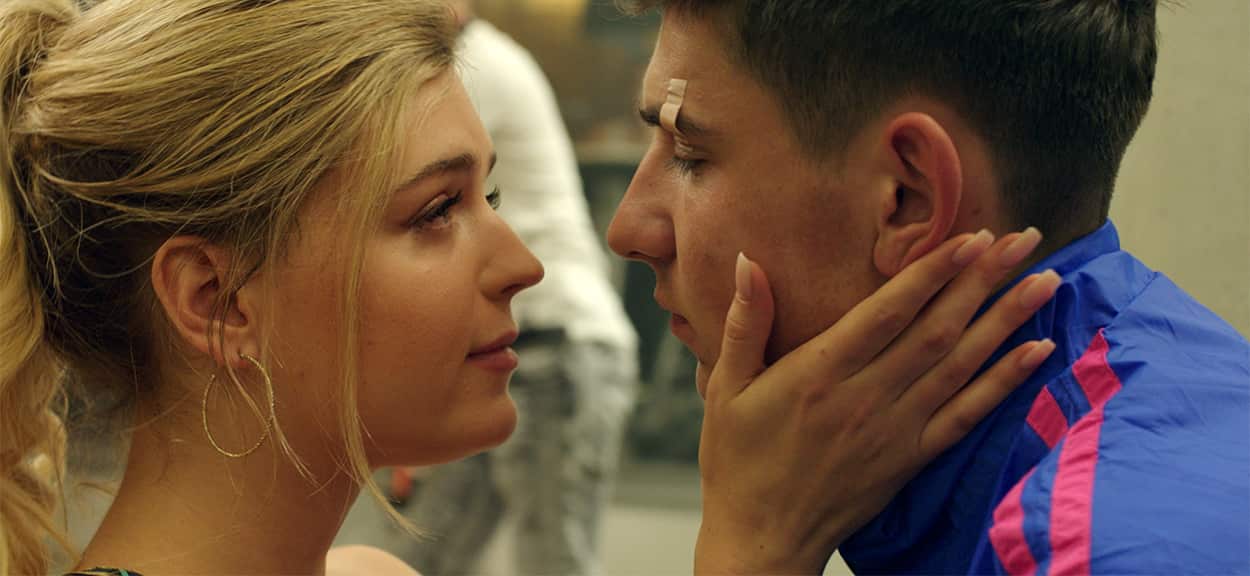 A young woman puts her hands on a young man's face and looks at him lovingly.jpg