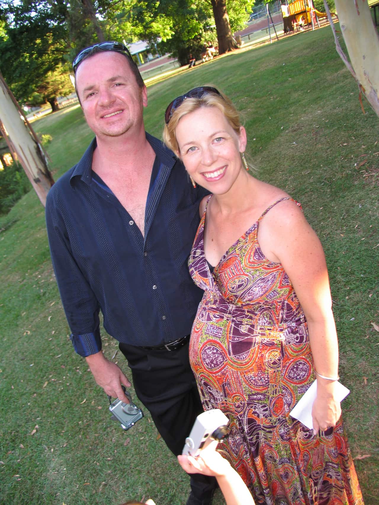 Pregnant woman standing with a man in a park