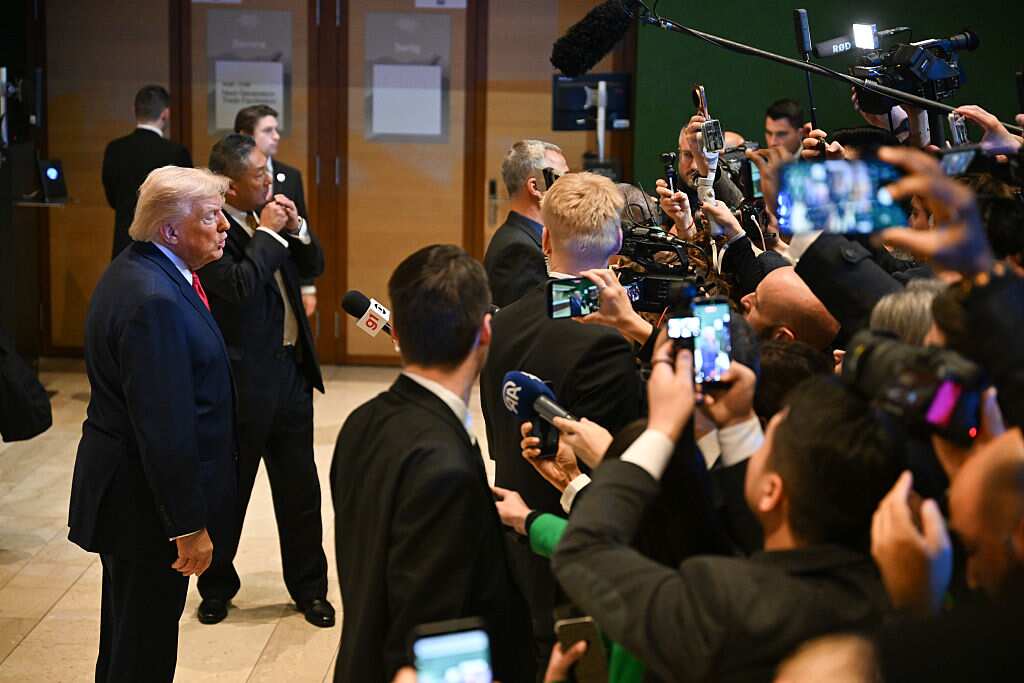 A man in a suit addresses waiting media.