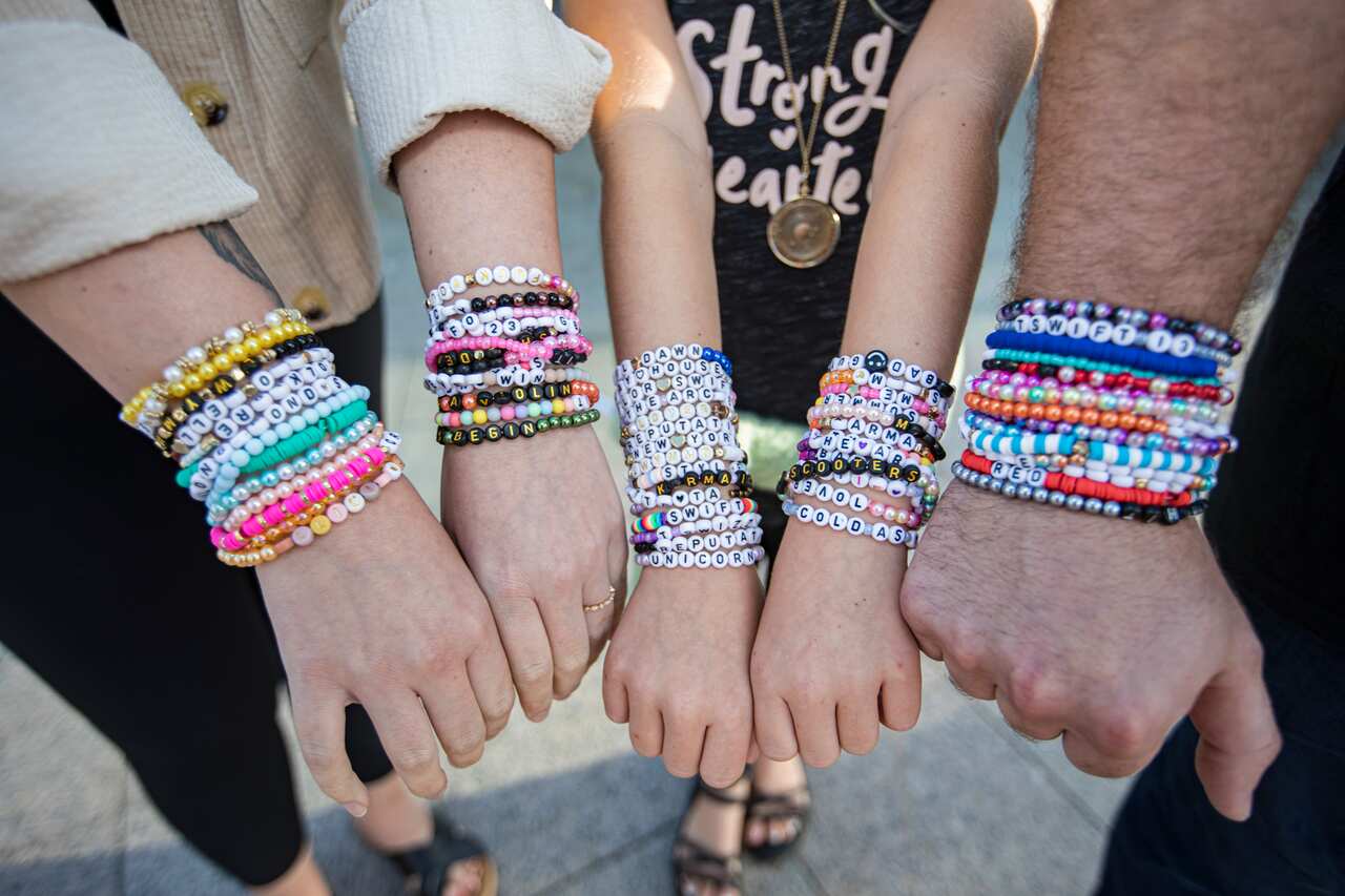 Five arms are decorated with colourful hand-made bracelets. 