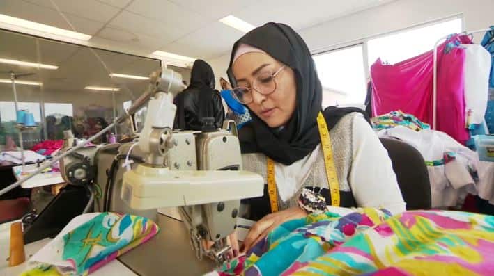 Sewing technician Soheyla Ramazani using a sewing machine and colourful fabric