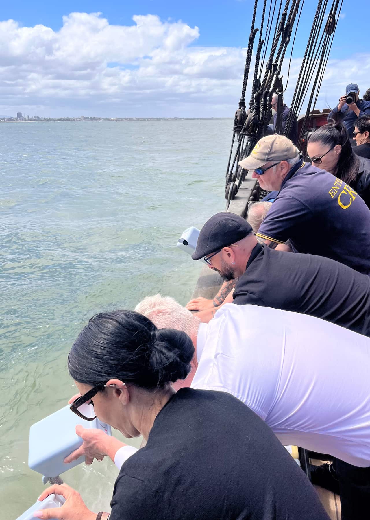 People scattering ashes off a boat.
