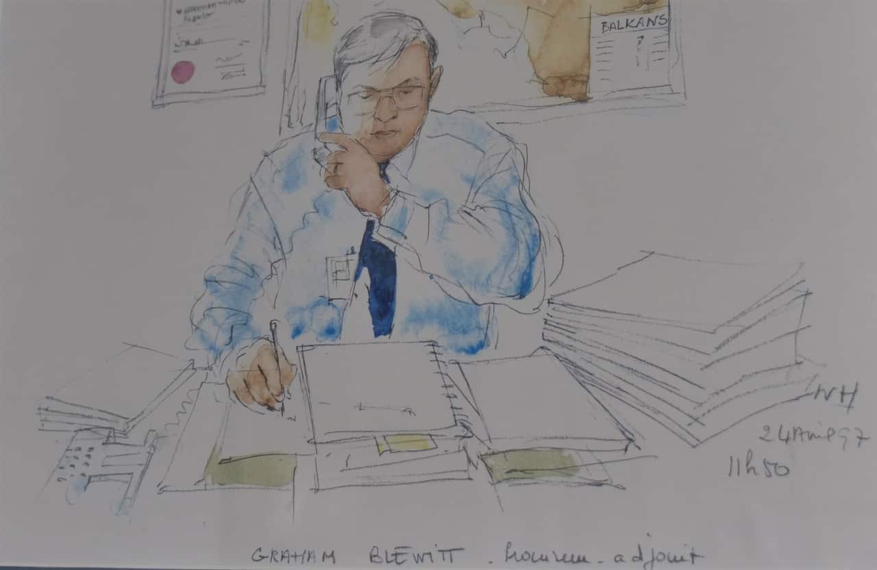 A sketch drawing coloured with watercolour shows a middle aged man sitting at a desk, a blue shirt and tie, holding a pen to paper. The desk is piled high and he bears a serious expression. Hanging on the wall behind him is a map of the Balkans and his degree.