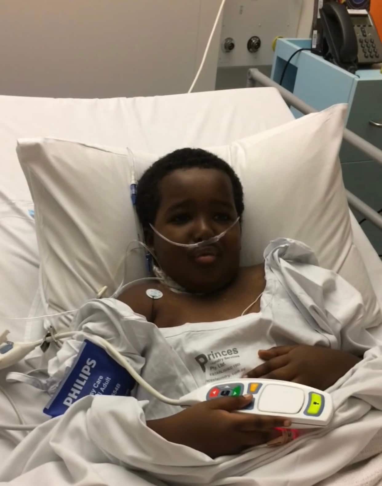 Hussein in hospital bed hooked up to tubes and a machine.