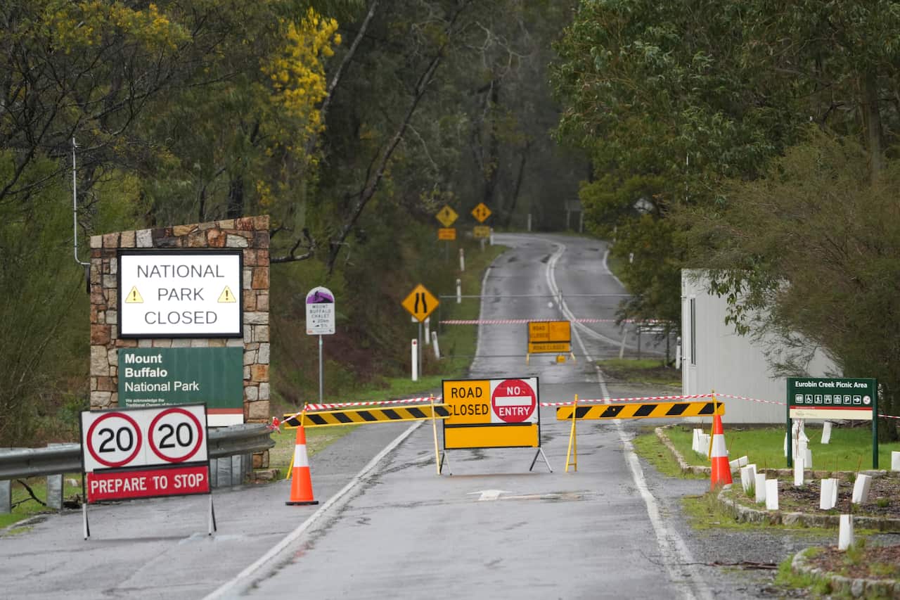 A road with yellow barriers across it. A sign says 'national park closed'.
