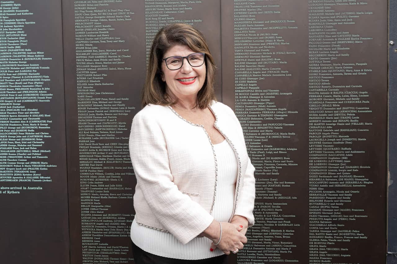 Paola Coluzzi, in front of the Welcome Wall which also displays her parents' names.