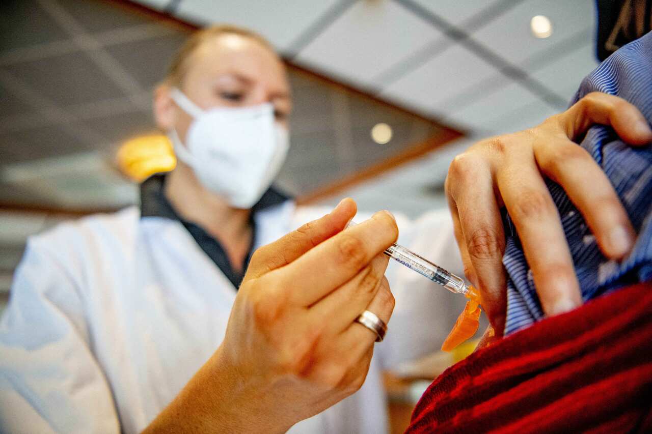 A nurse injecting a patient with the flu vaccine.