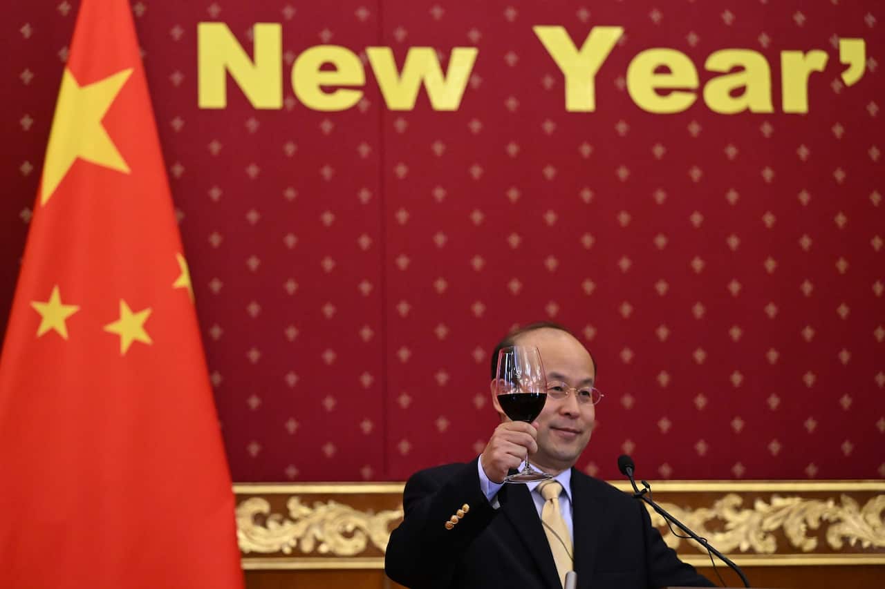 Chinese ambassador to Australia holds a wine glass as he makes a toast.