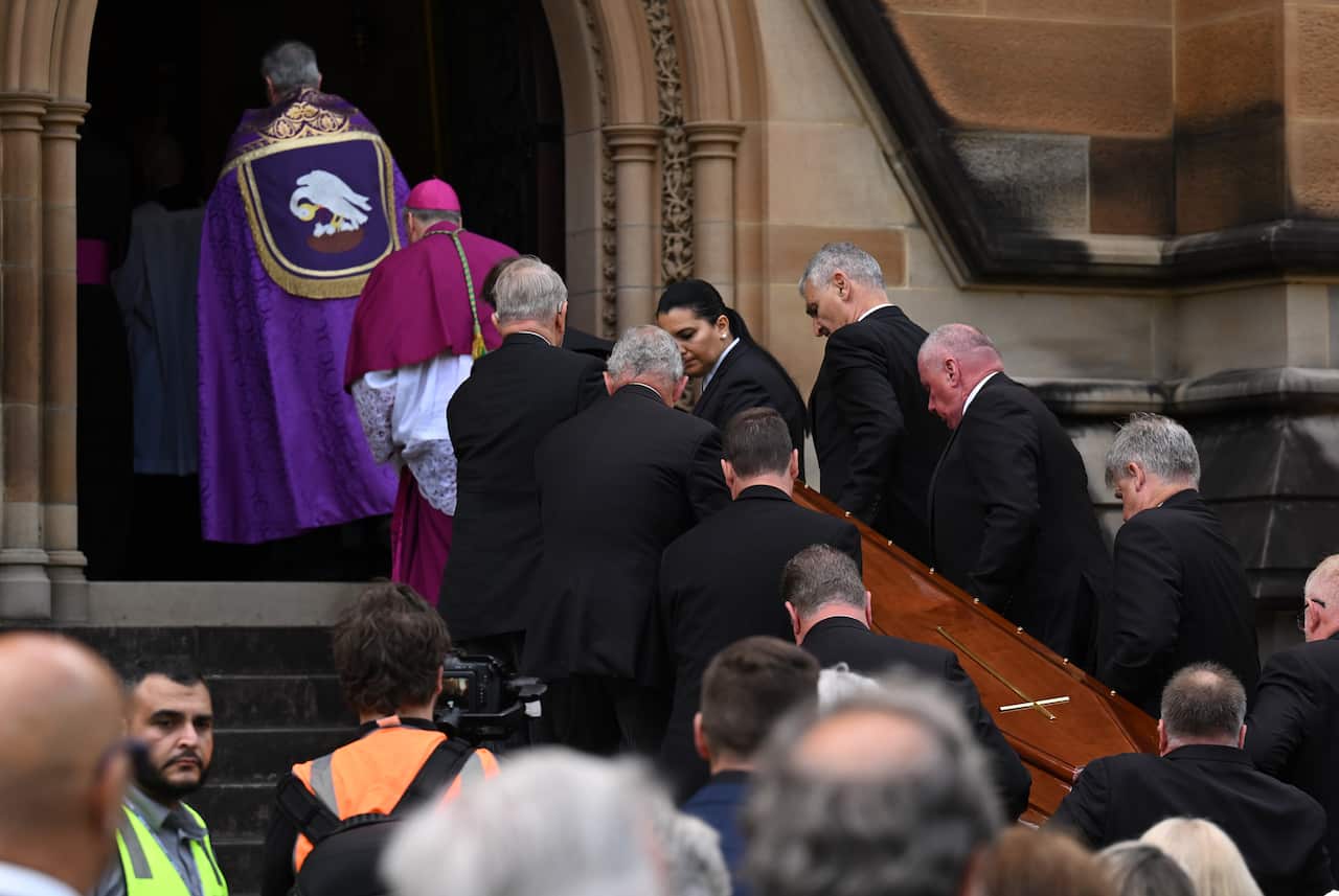 A coffin being carried into a church