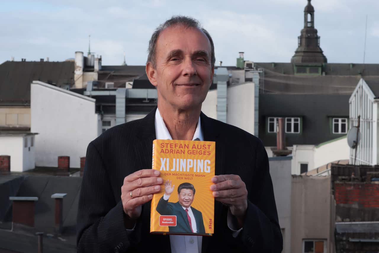 A man standing outside holding a book