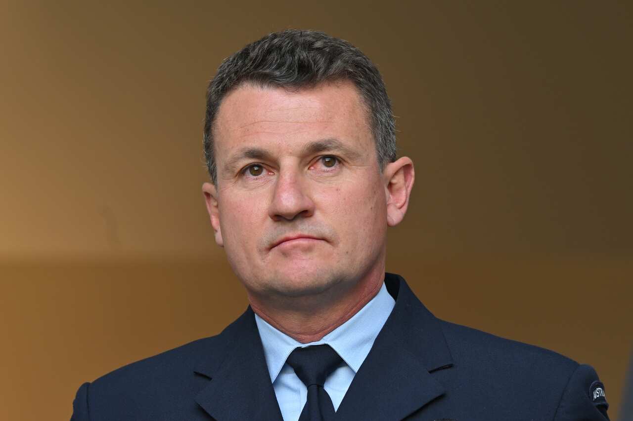 A man in a suit and tie at a press conference.