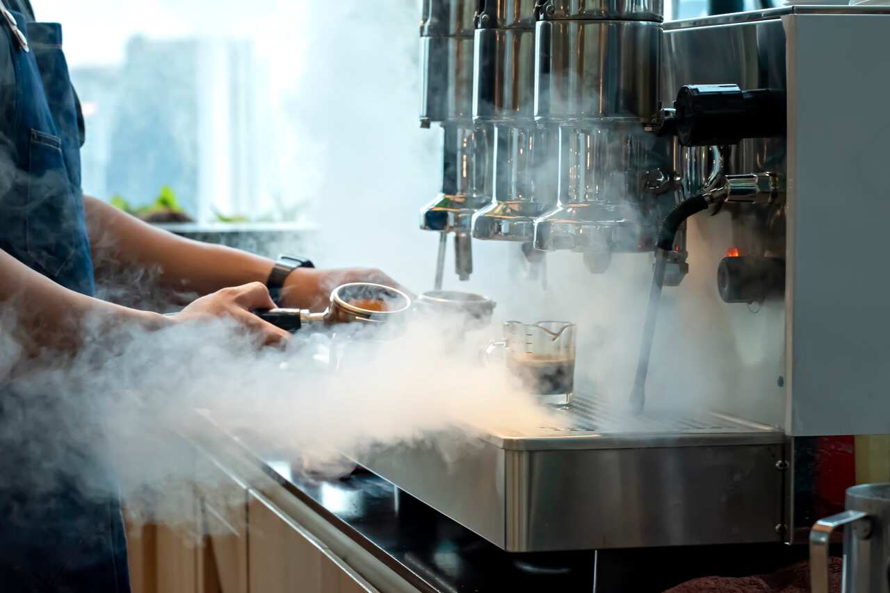 A barista working at a coffee machine.