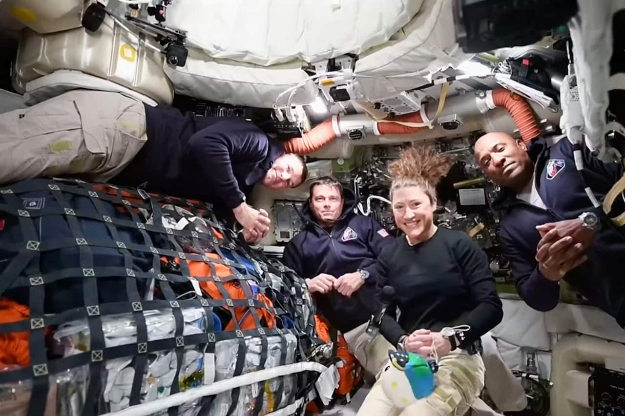 Four people inside a spacecraft floating in zero gravity 