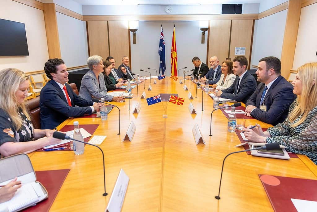 Australia's foreign minister Penny Wong and her delegation seated on one side of a table. North Macedonia's foreign minister Timčo Mucunski and his delegation are seated opposite.