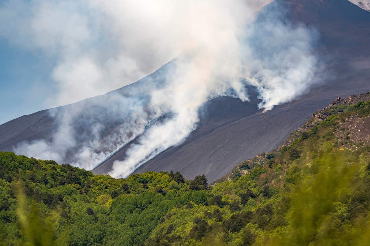 Smoke emanating from the cliffs of a volcano.