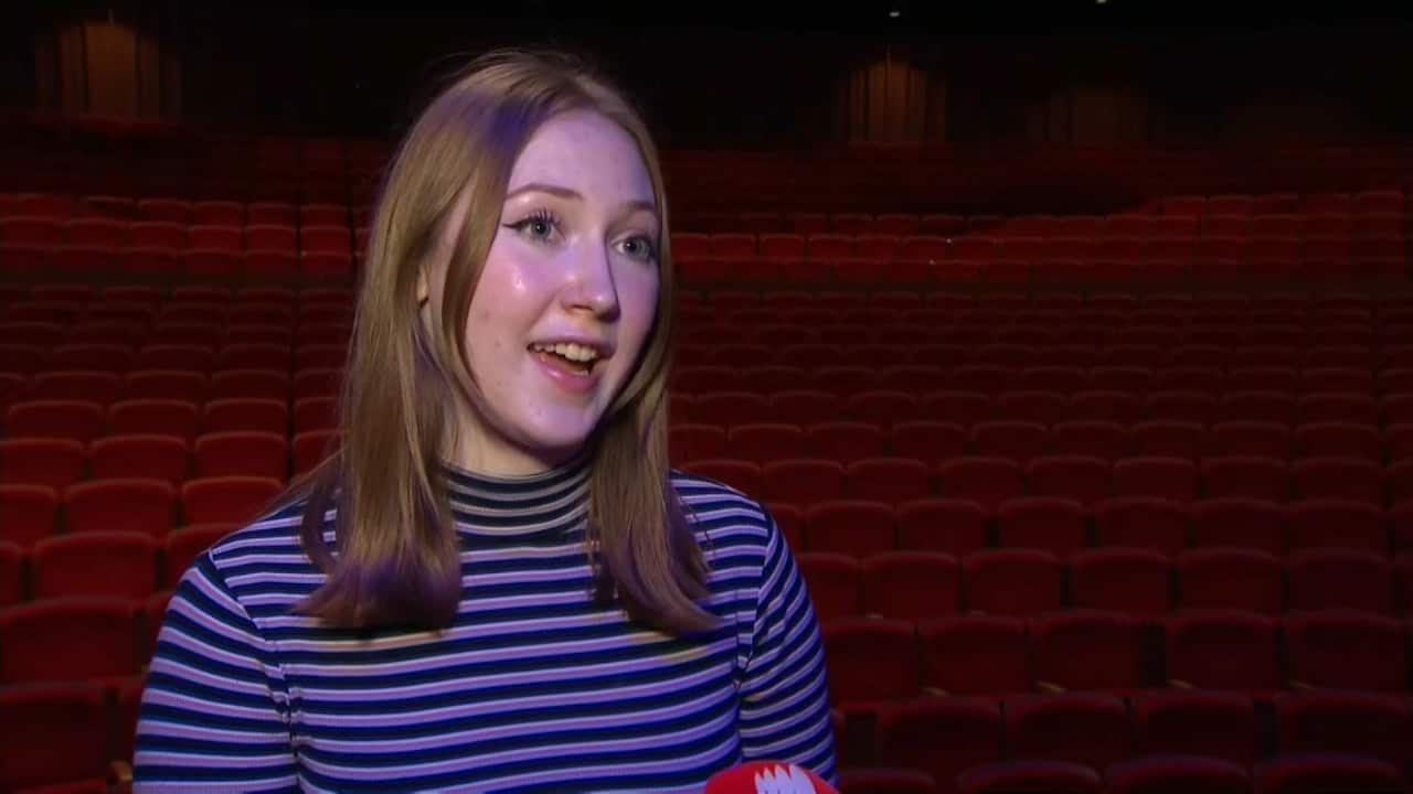 ANU student Bridget Shelley in a striped shirt is interviewed by SBS. 