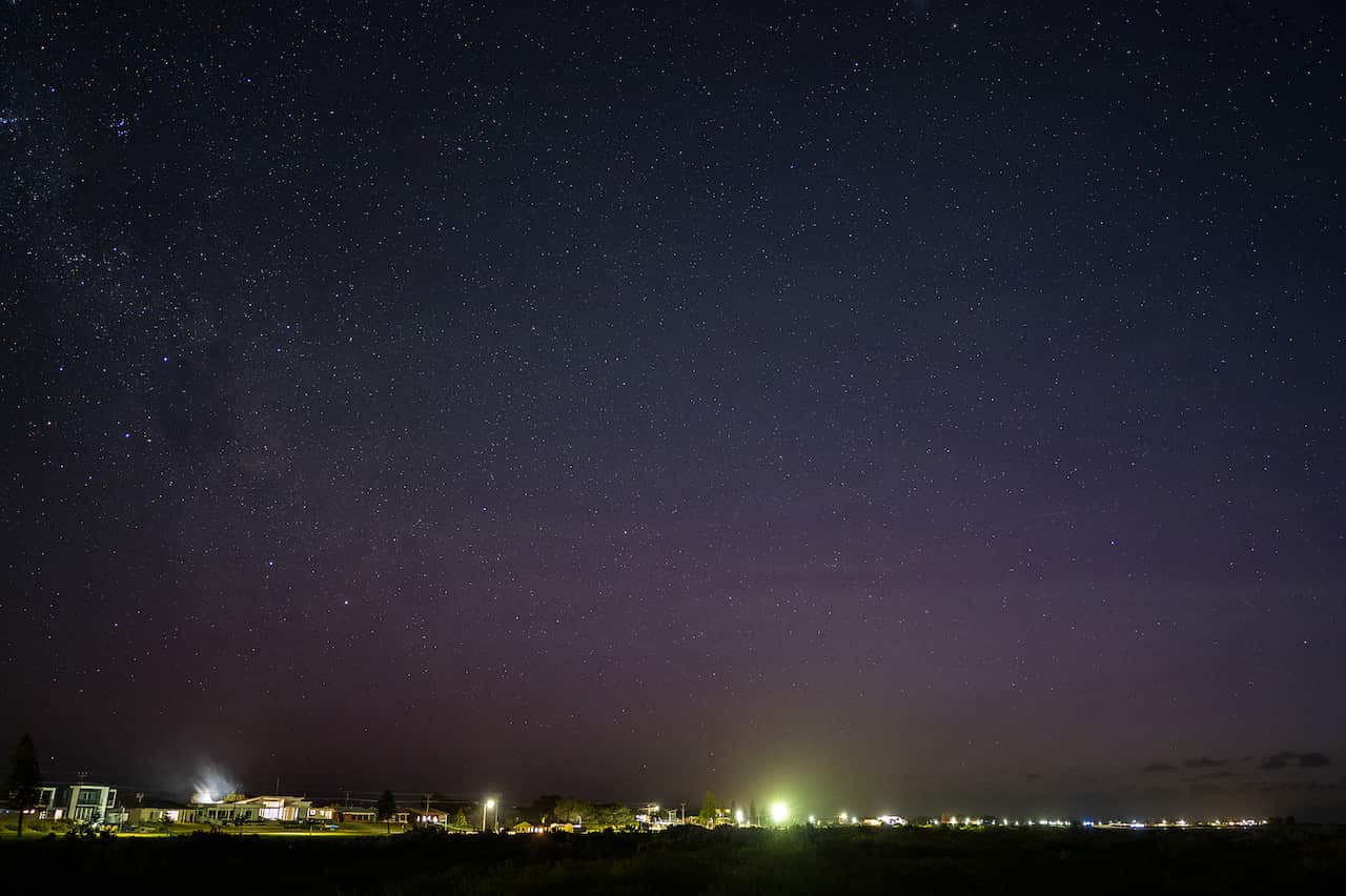 The night sky shines a purple hue.