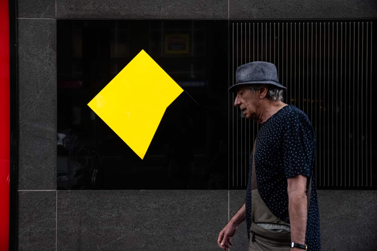 A man walks past Commonwealth Bank signage