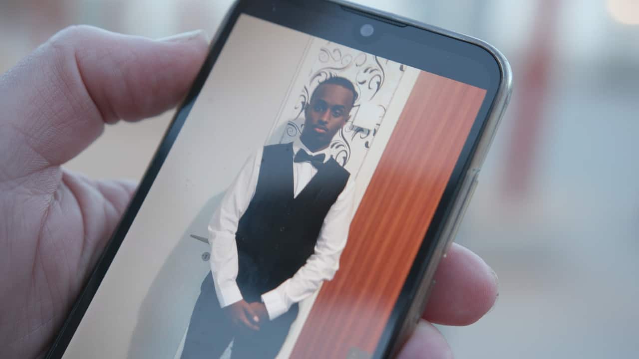 A photograph of a teenage boy on a mobile phone.