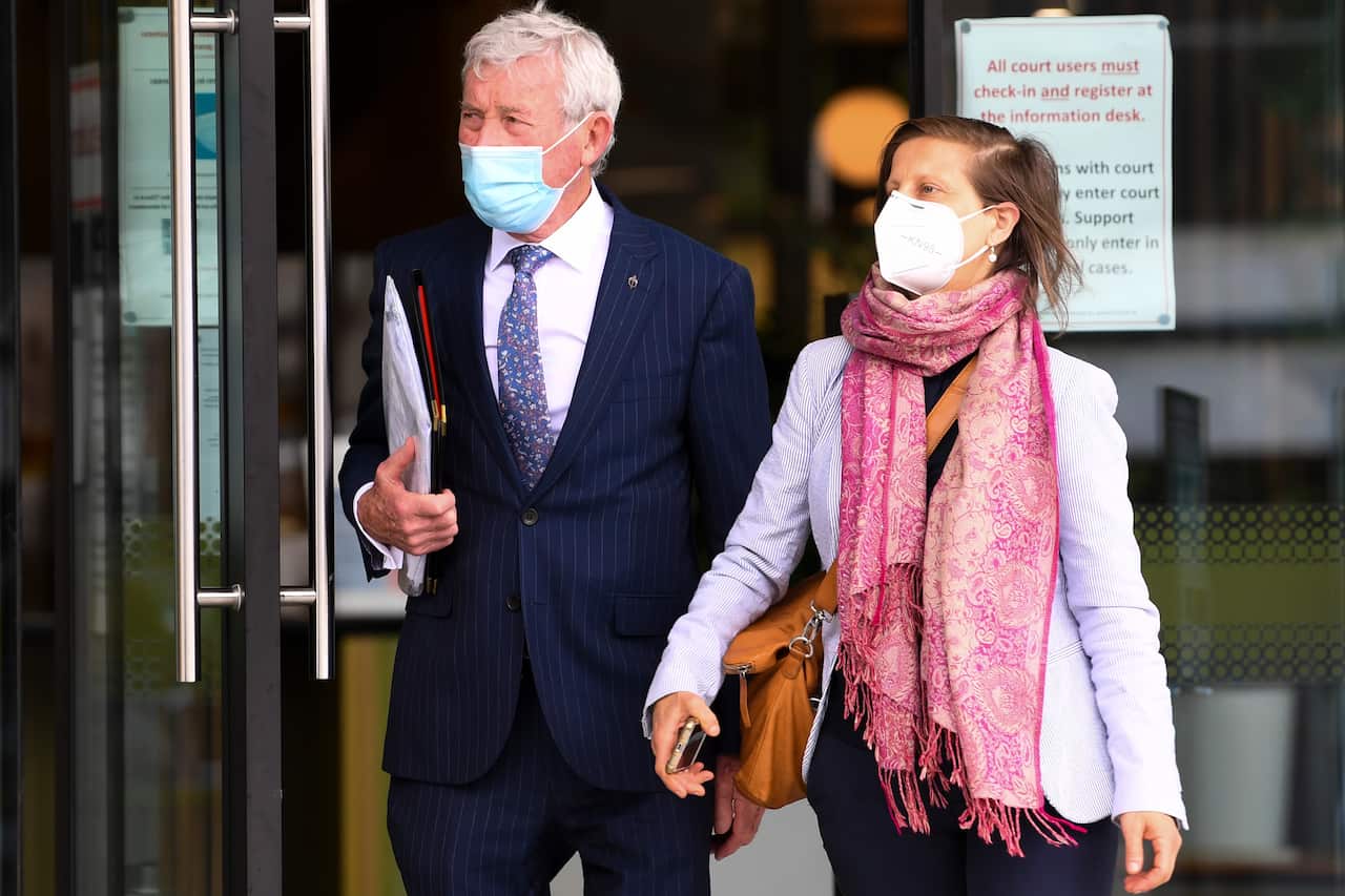 A man and a woman walking out of a building.