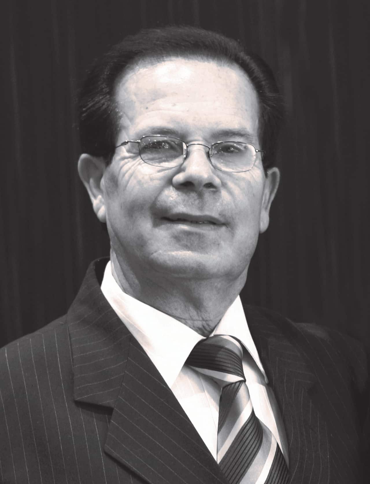 Black-and-white picture of a man in a suit jacket and tie.