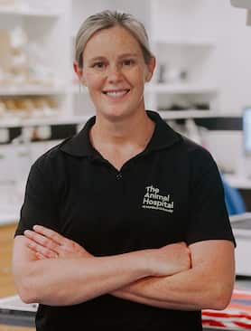 Claire Sharp with her arms crossed, wearing a shirt with 'The Animal Hospital' logo on it.
