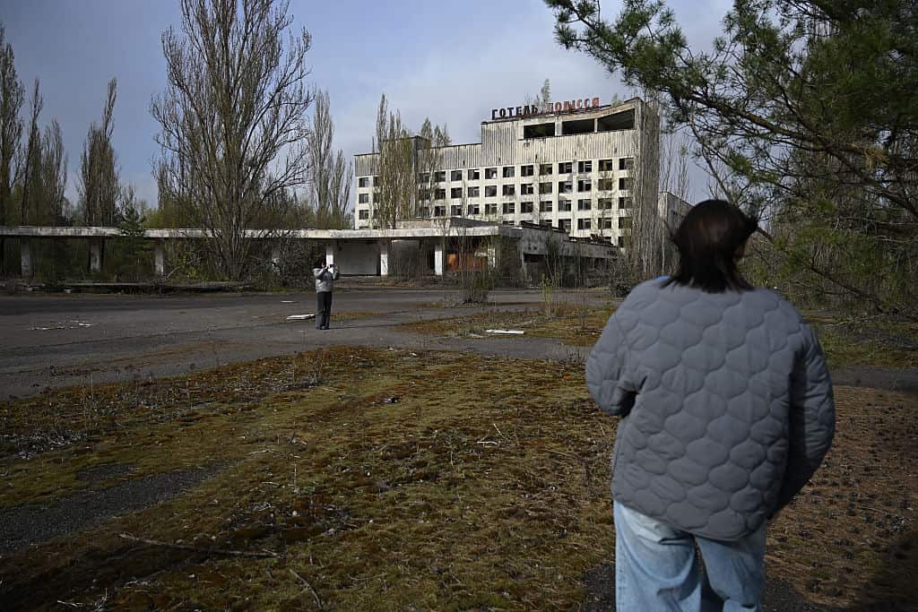Una persona mira desde atrás un hotel abandonado.