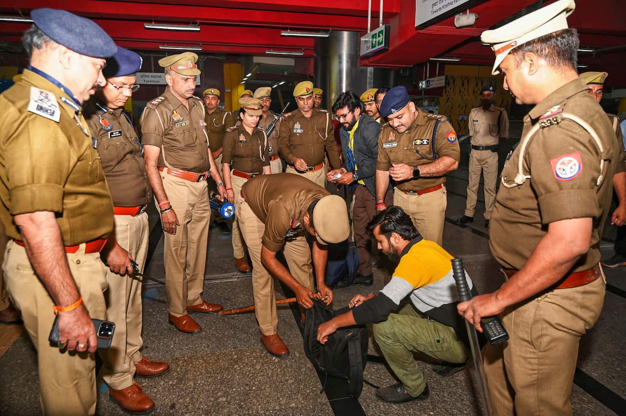 Group of men in uniform stand around as a bag is inspected