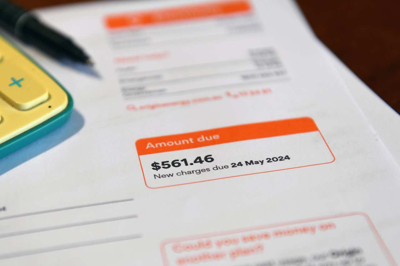 A calculator sitting on top of a bill with the amount $561.46 due. 