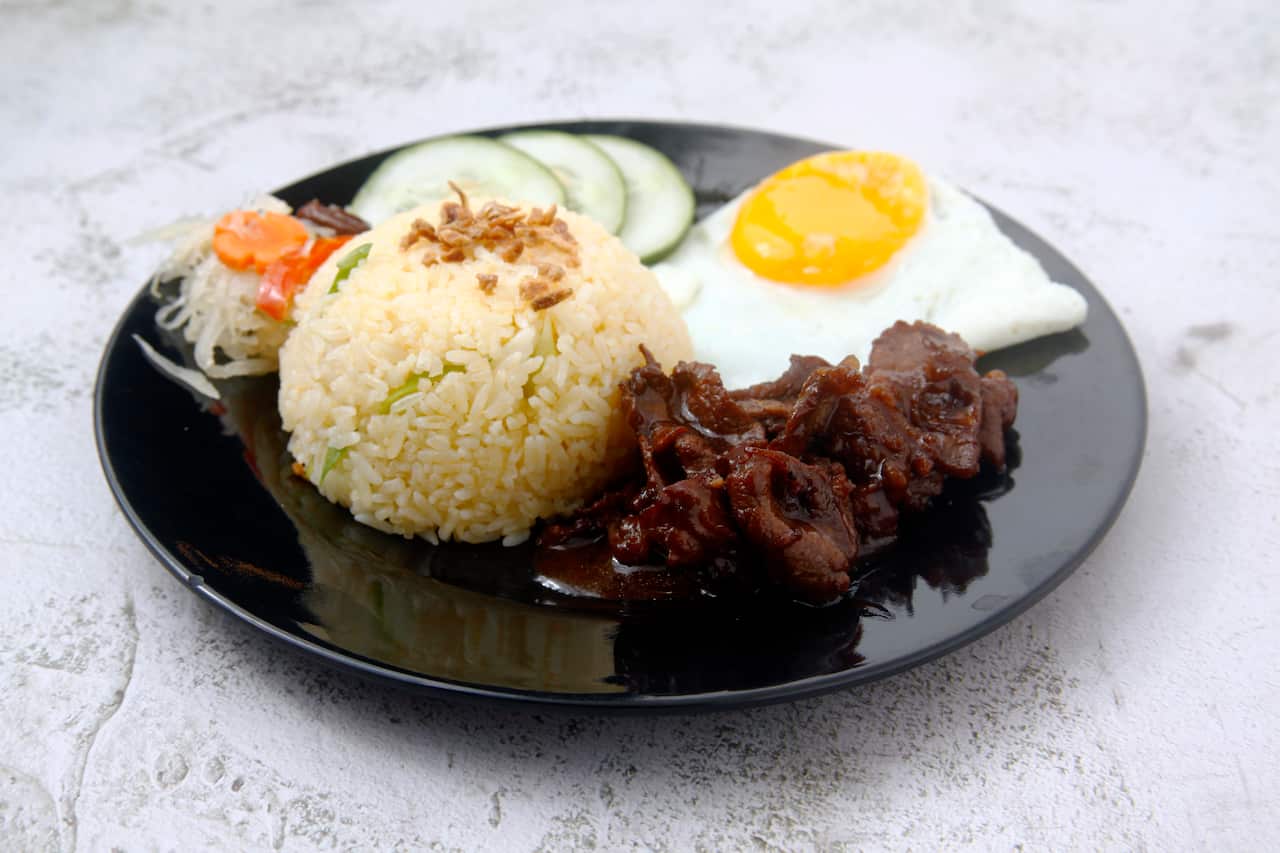 reshly cooked Filipino food called Tapsilog or thin beef slices, egg and fried rice