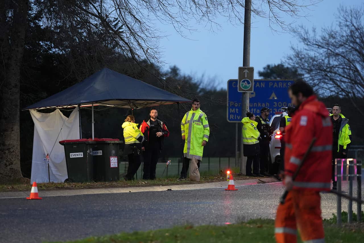 Police standing together at a crime scene.