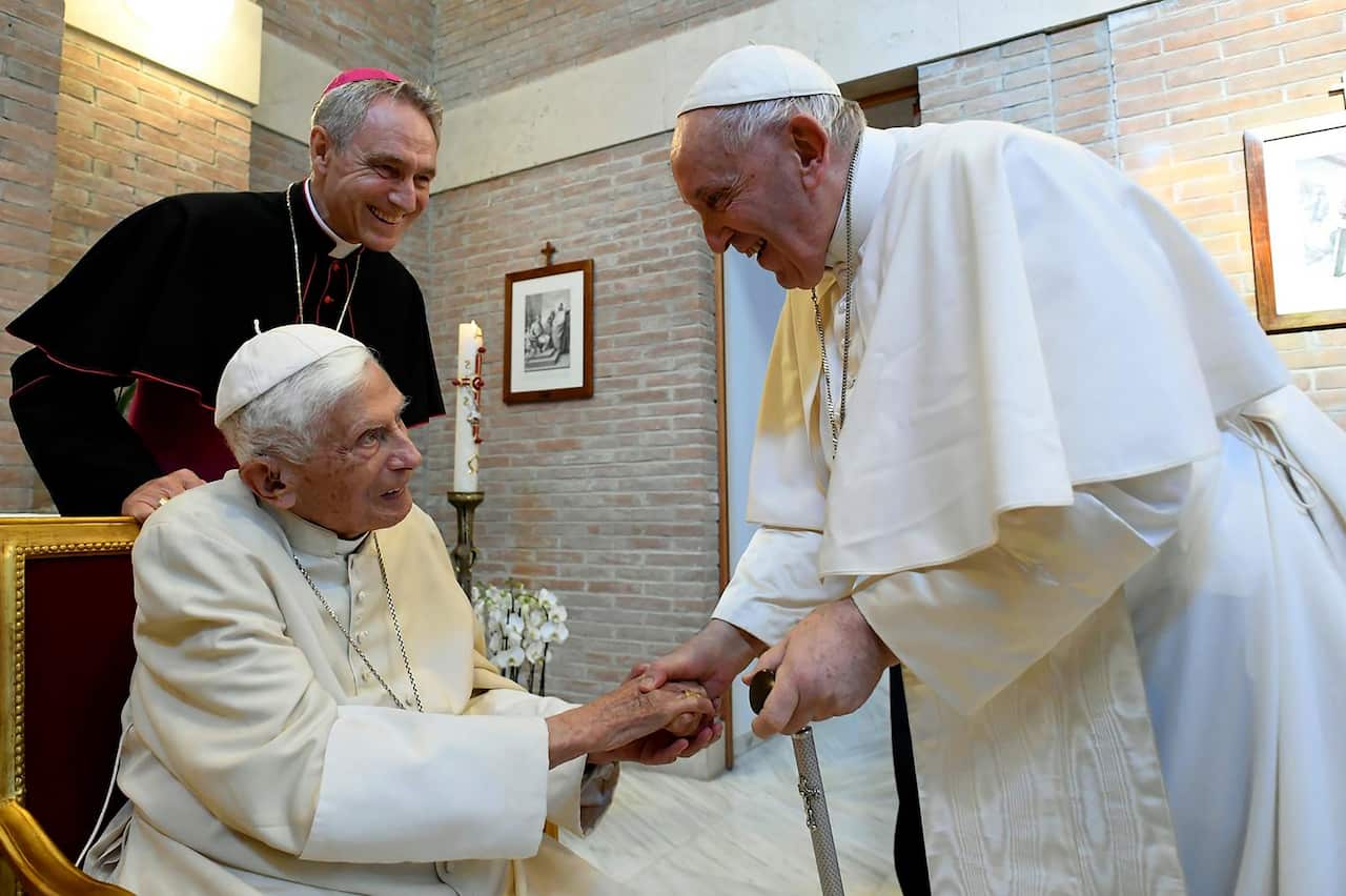 Pope Francis greets Pope Benedict.