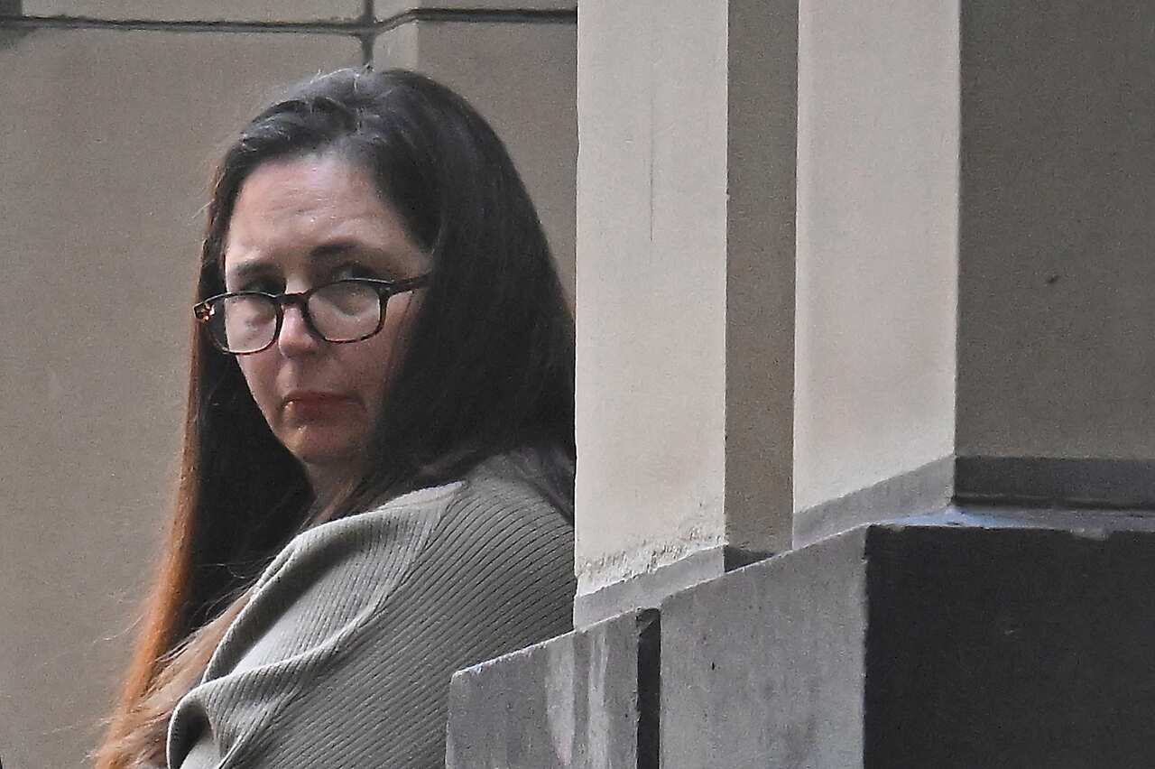 A woman in long brown hair wearing glasses