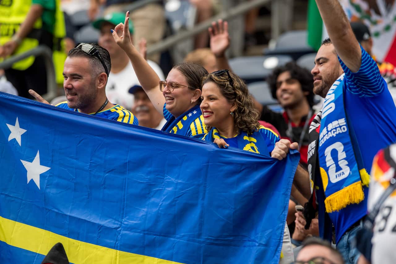 Curaçao fans hold blue flags