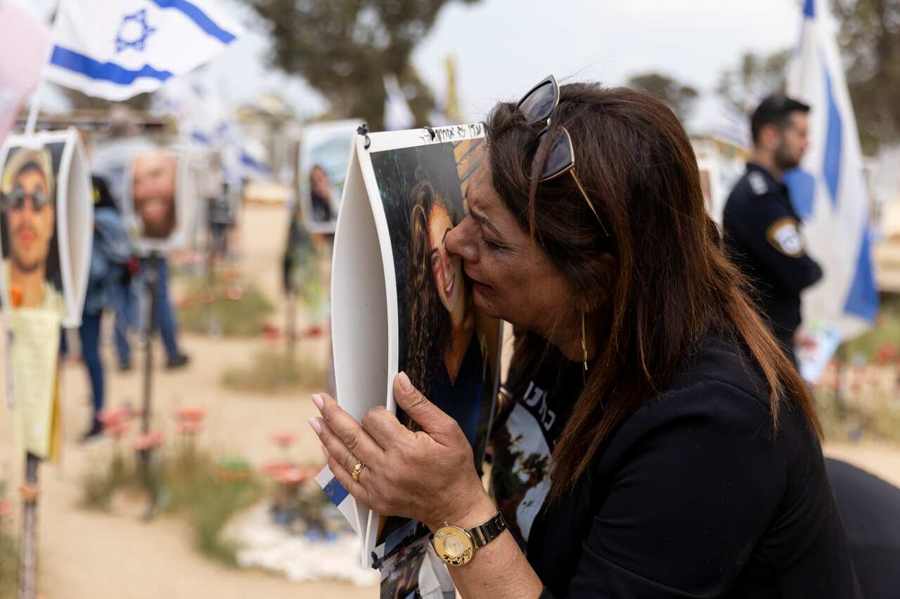 A person kisses a poster with a portrait on it