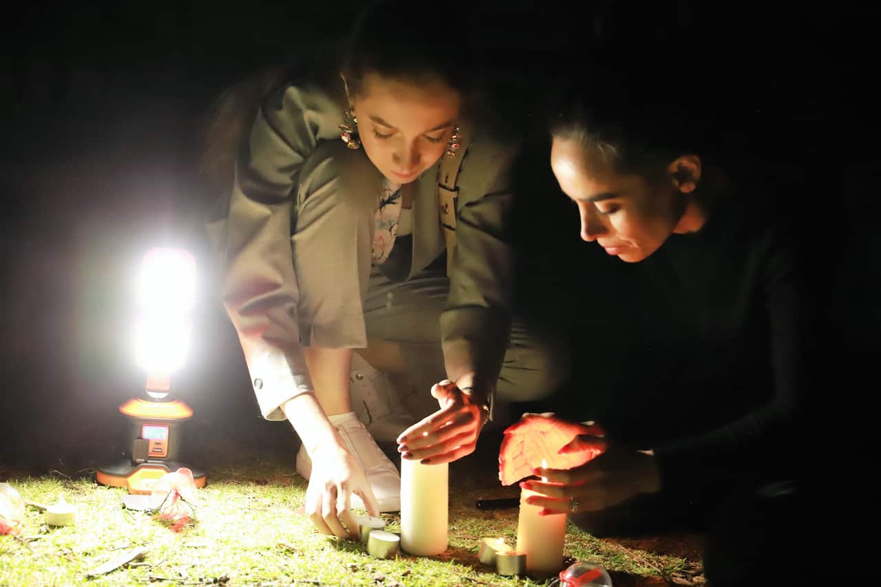 young girls lightening candle for people who recently lost their life in Iran