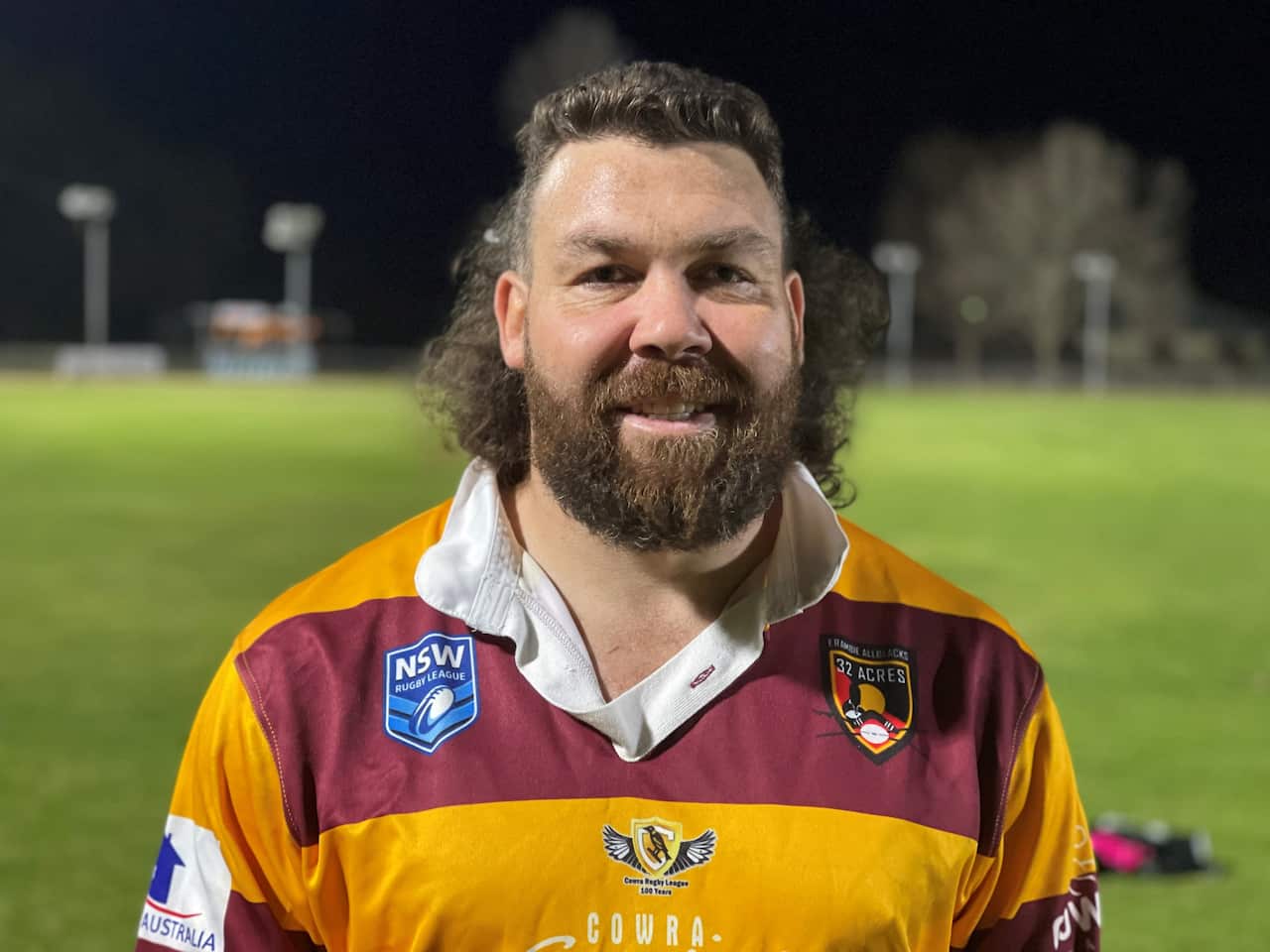 Head and shoulders shot of Wiradjuri Erambie All Blacks player William Ingram proudly wearing his crimson and yellow rugby league jersey.