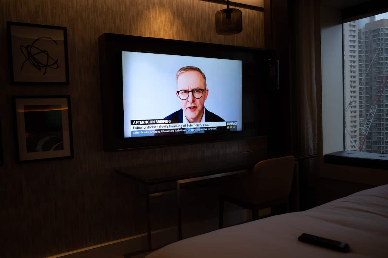 Opposition Leader Anthony Albanese is seen on a TV screen as he conducts an interview via video link after testing positive for COVID on Day 12 of the federal election campaign.