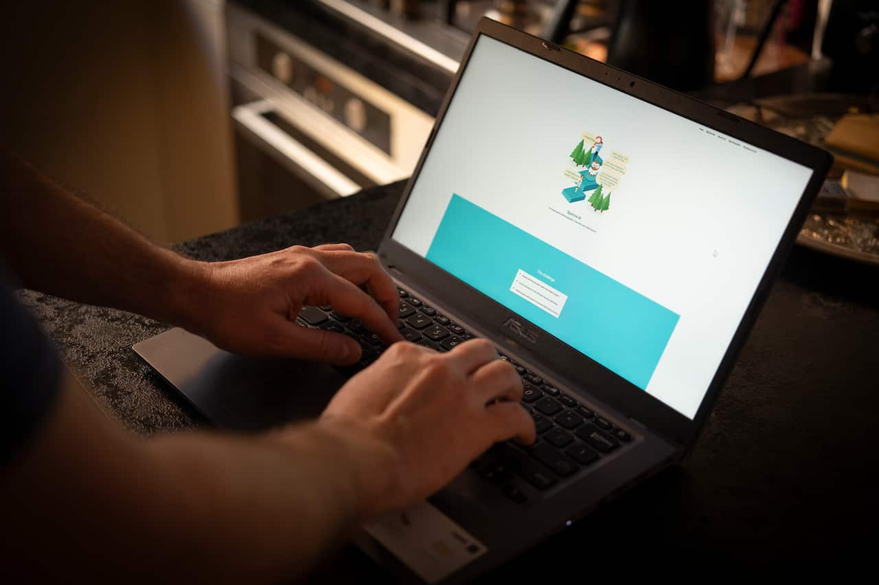 Hands on the keyboard of a laptop, with an artificial intelligence interface open on the screen. 