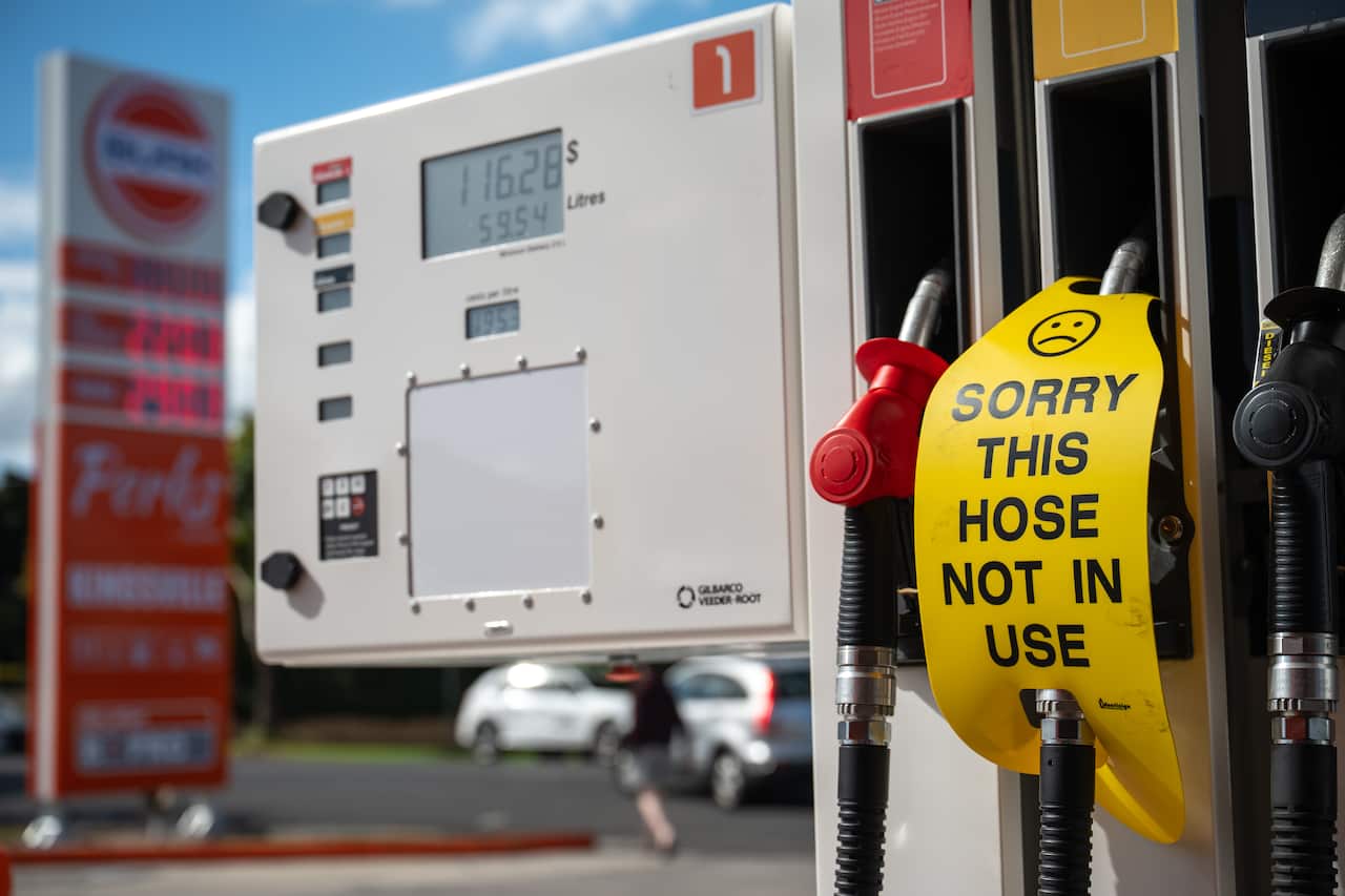 A sign saying 'sorry this hose not in use' on a petrol bowser at a service station